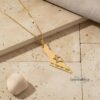 14K gold Israel map pendant photographed on Jerusalem stone tiles