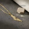 Solid gold Israel map pendant against a slate background