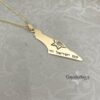 14K gold Israel map necklace on a pale patterned surface