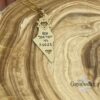 Solid gold Israel map memorial necklace on patterned wood