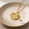 Gold Shema Israel necklace resting in a ceramic dish