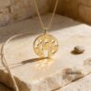 14K gold Shema Israel pendant on Jerusalem stone in sunlight