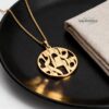 Gold Shema Israel necklace on a black plate with linen