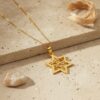 Gold Star of David necklace on stone with linen