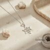 White gold Magen David necklace on a pale stone ledge