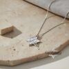 White gold layered Star of David necklace on travertine