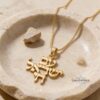 Gold Am Yisrael Chai Hebrew pendant displayed in a stone dish