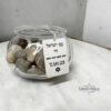 Engraved silver dog tag necklace hanging from a glass jar
