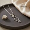 Silver Israel map necklace displayed on a dark ceramic dish