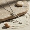 Silver Israel map outline pendant photographed on sand