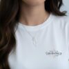 Model wearing the silver Israel map necklace with a white top