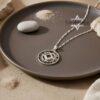 Silver openwork nano Bible pendant on a dark ceramic plate
