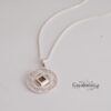 Sterling silver openwork Shema pendant on a pale background