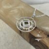 Openwork Shema Yisrael pendant photographed against textured paper