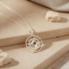 Silver Shema Yisrael circle necklace styled on travertine with linen