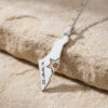 Sterling silver Israel map necklace with cut-out Star of David engraved עם ישראל חי, resting on a stone