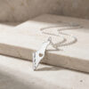 925 sterling silver engraved Israel map necklace with cut-out heart resting on travertine stone