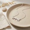 Sterling silver Hebrew name necklace in a ceramic dish, a Bat Mitzvah gift idea