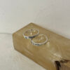 Two sterling silver Hebrew name rings with birthstones on a stone block