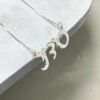 Sterling silver Hebrew name pendant on a stone surface, close up
