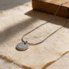 Silver zircon halo pendant with a smooth blank center disc on stone