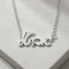 Silver Hebrew name necklace with cable chain on a grey stone