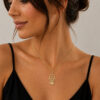 Woman wearing a delicate 14K yellow gold Hamsa necklace with a Star of David