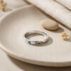 Sterling silver Hebrew name ring with birthstone on a ceramic dish