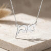 Hebrew name pendant in sterling silver casting a shadow on stone