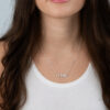 Woman wearing a dainty silver Hebrew name necklace