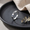 Sterling silver Hebrew name ring with birthstone on a dark plate