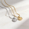 Silver and gold zircon halo round pendant necklaces lying side by side