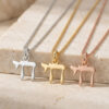 Three mini Chai necklaces in silver, gold and rose gold on travertine stone