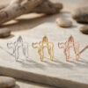 Open outline Hebrew Chai pendants in silver, gold and rose gold displayed on stone