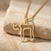 Gold open outline Hebrew Chai necklace draped over a travertine stone block