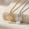 14K yellow gold and 14K white gold Hamsa Star of David necklaces on travertine stone