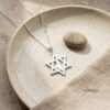 Star of David Necklace with Israel Map Cut-Out — silver pendant on a stone dish with pebble