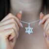 Star of David Necklace with Israel Map Cut-Out — pendant held between the fingers for scale