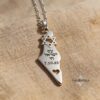 Am Yisrael Chai Israel Map Necklace — pendant photographed on fine sand
