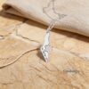 Israel Map Necklace with Cut-Out Star of David — pendant flat on a pale woven cloth