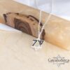 Sterling silver October 7 Star of David necklace hanging against a wood and marble background