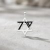 Detail of the October 7 Star of David pendant in 925 sterling silver on a light stone surface