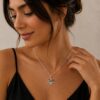 Woman in a black top wearing the silver October 7 Star of David necklace, a meaningful Jewish gift
