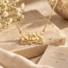 14K gold Ima necklace on a travertine stone beside a card for Mom