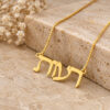 Close-up of a 14K yellow gold Hebrew name necklace on stone with dried flowers, showing the smooth letter edges.