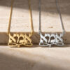 14K yellow gold and white gold Hebrew Ima necklaces together on stone