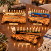 White, blue and black olive wood Hanukkah menorahs on a festive table