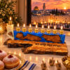 Blue olive wood Hanukkah menorah on a Hanukkah table with sufganiyot and dreidels
