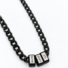 Black stainless steel Cuban chain with engraved Hebrew name beads, side view on a white background