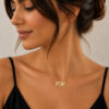 Woman wearing a 14K yellow gold Hebrew name necklace for Mom with a black top